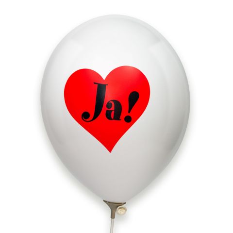 Weißer Luftballon mit aufgedrucktem rotem Herz in dem "Ja!" in schwarz steht.