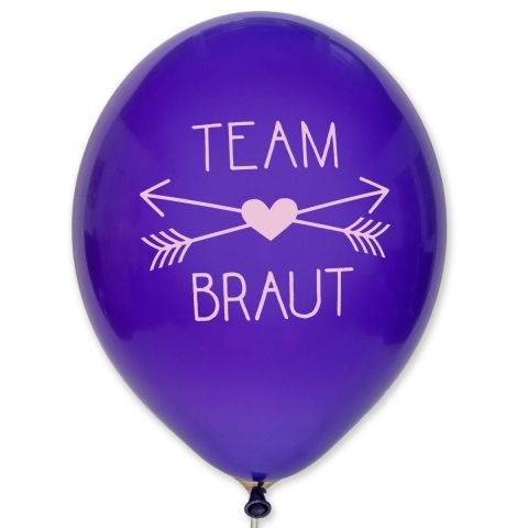 Luftballon in königslia mit einem rosafarbenen Aufdruck "TEAM BRAUT". Zwischen den beiden Zeilen sind 2 gekreuzte Pfeile mit einem mittigen Herz.