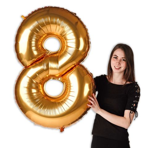 Goldener Folienballon in Form von Zahl "8" im Verhältnis zu einer Person zu sehen.